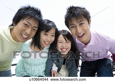 Portrait of four young people smiling and looking at camera, bending over, front view, white background, Japan View Large Photo Image Picture - Portrait of four young people smiling and looking at camera, bending over, front view, white background, Japan. Fotosearch