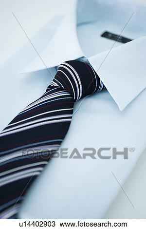 Stock Image - Folded shirt and tie, high angle view, close up, white background, Japan. Fotosearch
