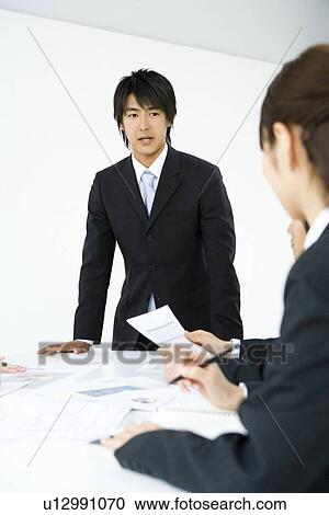Three young business people in meeting, front view, side view, white background, Japan View Large Photo Image Stock Image - Three young business people in meeting, front view, side view, white background, Japan. Fotosearch