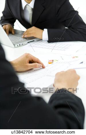 Picture - Two young businessmen in meeting, front view, side view, Japan. Fotosearch