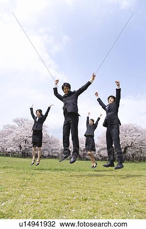 Young business people jumping at the field of cherry blossoms, low angle view, copy space, Japan View Large Photo Image Stock Image - Young business people jumping at the field of cherry blossoms, low angle view, copy space, Japan. Fotosearch