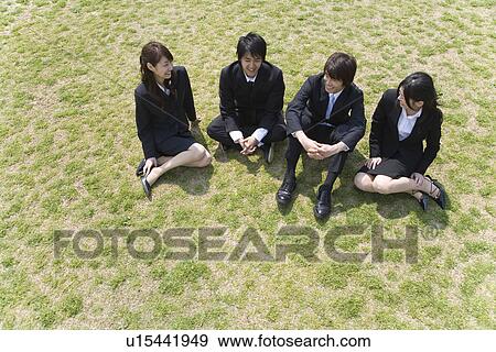 Young business people sitting down on the lawn, high angle view, Japan View Large Photo Image Stock Photo - Young business people sitting down on the lawn, high angle view, Japan. Fotosearch