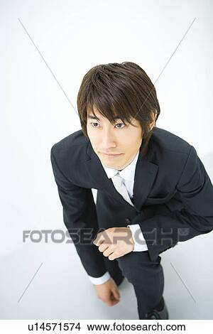 Young businessman kneeling, high angle view, white background, Japan View Large Photo Image Picture - Young businessman kneeling, high angle view, white background, Japan. Fotosearch