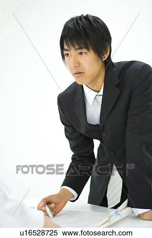 Stock Photography - Young businessmen in meeting, front view, white background, Japan. Fotosearch