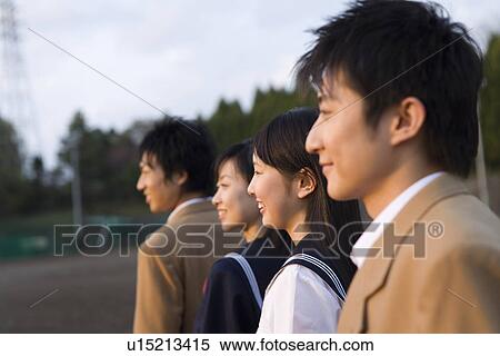 Four teenagers smiling and standing side by side in schoolyard, side view, Japan View Large Photo Image Stock Photography - Four teenagers smiling and standing side by side in schoolyard, side view, Japan. Fotosearch