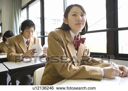 Stock Photograph - High school students sitting at desk in class, side view, front view. Fotosearch