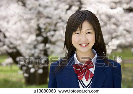 Portrait of a teenage girl smiling and looking at camera, cherry trees in background, front view, Japan View Large Photo Image Stock Image - Portrait of a teenage girl smiling and looking at camera, cherry trees in background, front view, Japan. Fotosearch