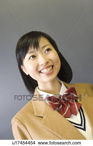 Portrait of a teenage girl smiling, front view, gray background View Large Photo Image Picture - Portrait of a teenage girl smiling, front view, gray background. Fotosearch