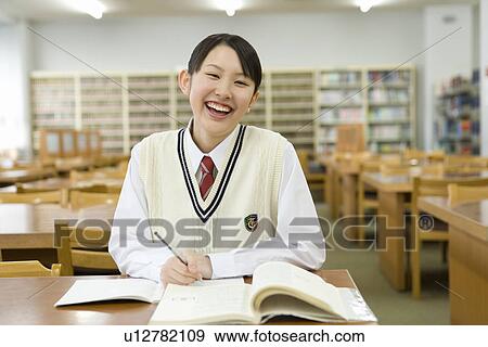 Portrait of a teenage girl studying in library, smiling and looking at camera, front view View Large Photo Image Stock Photo - Portrait of a teenage girl studying in library, smiling and looking at camera, front view. Fotosearch