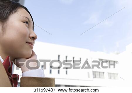 Teenage girl resting chin in hand, smiling, side view View Large Photo Image Stock Photo - Teenage girl resting chin in hand, smiling, side view. Fotosearch