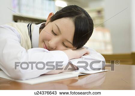 Teenage girl sleeping at table in library, side view View Large Photo Image Stock Image - Teenage girl sleeping at table in library, side view. Fotosearch