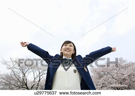 Teenage girl stretching arms out under the blue sky, cherry trees in the background, low angle view, Japan View Large Photo Image Stock Photo - Teenage girl stretching arms out under the blue sky, cherry trees in the background, low angle view, Japan. Fotosearch