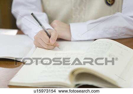 Picture - Teenage girl studying in library, high angle view. Fotosearch