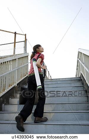 Stock Photography - Young Woman Going Up Stairs, Looking Up to the Sky. Fotosearch