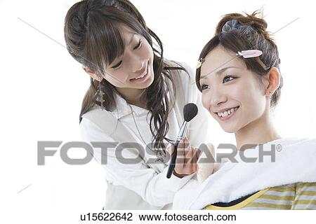 Stock Image - Young Women Applying Makeup. Fotosearch