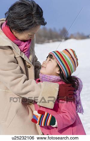 Stock Photograph - Girl looking up at her grandmother, smiling. Fotosearch