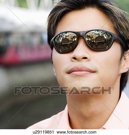 Close-up of a young man wearing sunglasses View Large Photo Image Stock Image - Close-up of a young man wearing sunglasses. Fotosearch