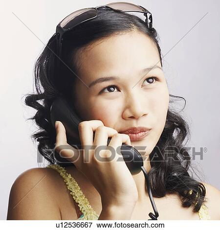 Close-up of a young woman on the phone View Large Photo Image Stock Photo - Close-up of a young woman on the phone. Fotosearch