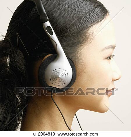 Stock Photo - Close-up of a young woman wearing headphones. Fotosearch