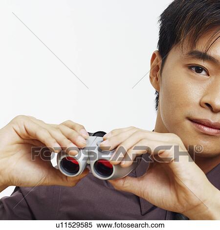 Stock Photography - Portrait of a businessman holding a pair of binoculars. Fotosearch