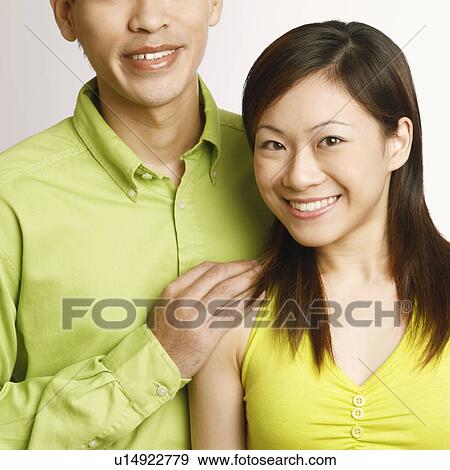 Stock Photo - Portrait of a mid adult man and a young woman posing and smiling. Fotosearch