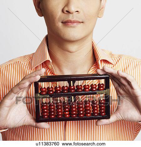Stock Image - Portrait of a young man holding an abacus. Fotosearch