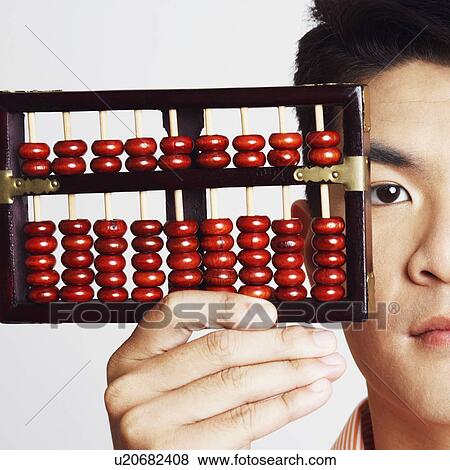 Stock Photo - Portrait of a young man holding an abacus. Fotosearch