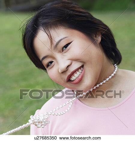 Stock Image - Portrait of a young woman smiling. Fotosearch