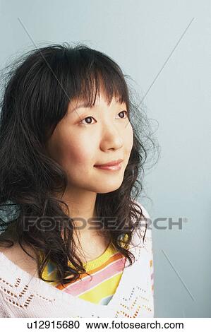 Stock Image - Close-up of a young woman looking away smiling. Fotosearch