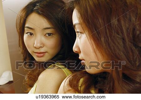 Stock Photography - Close-up of a young woman looking in the mirror. Fotosearch
