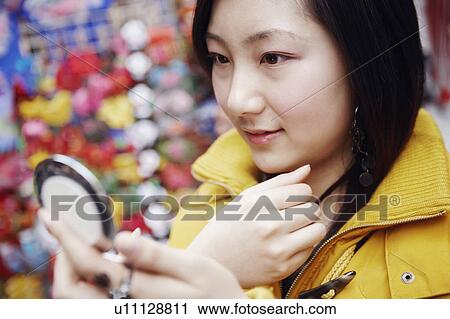 Close-up of a young woman looking into a vanity mirror View Large Photo Image Stock Image - Close-up of a young woman looking into a vanity mirror. Fotosearch