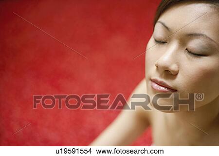 Picture - Close-up of a young woman with her eyes closed. Fotosearch