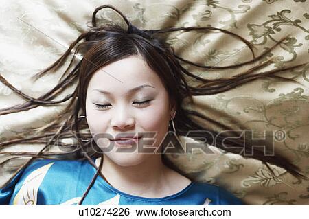 Stock Photograph - High angle view of a young woman with her eyes closed. Fotosearch