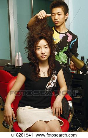 Male hairdresser drying a young woman's hair View Large Photo Image Stock Image - Male hairdresser drying a young woman's hair. Fotosearch
