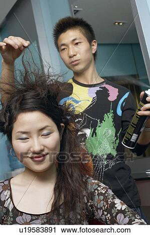 Male hairdresser styling a young woman's hair View Large Photo Image Stock Image - Male hairdresser styling a young woman's hair. Fotosearch