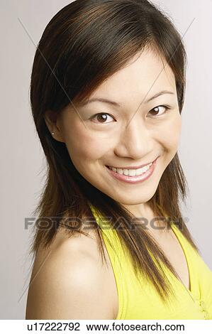 Stock Image - Portrait of a young woman posing and smiling. Fotosearch