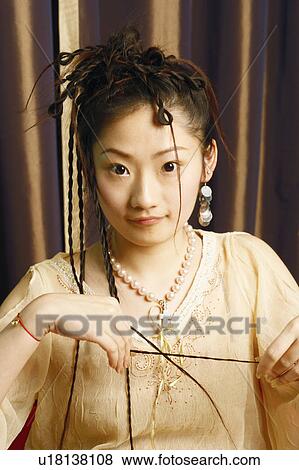 Stock Photo - Portrait of a young woman sitting on a chair. Fotosearch