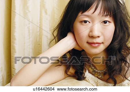 Portrait of a young woman thinking with her hands on her cheek View Large Photo Image Picture - Portrait of a young woman thinking with her hands on her cheek. Fotosearch