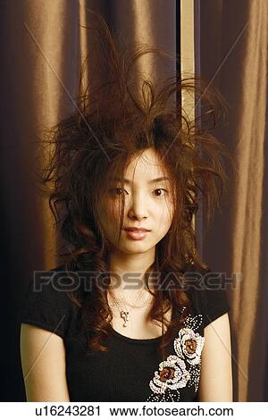 Stock Image - Portrait of a young woman with tousled hair. Fotosearch