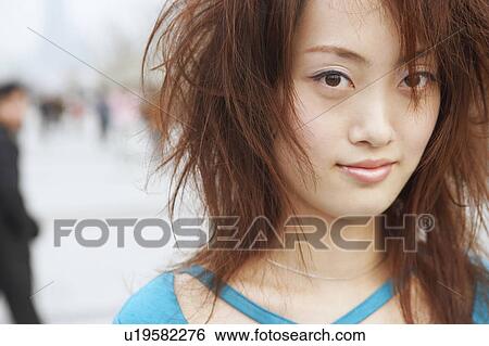 Stock Photograph - Portrait of a young woman with tousled hair. Fotosearch