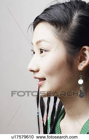 Stock Image - Side profile of a young woman smiling. Fotosearch
