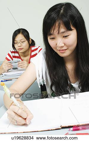 Close-up of a young woman writing on a notepad View Large Photo Image Picture - Close-up of a young woman writing on a notepad. Fotosearch