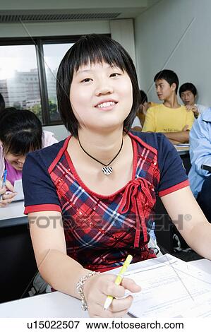Stock Photo - Close-up of students sitting in a classroom and smiling. Fotosearch