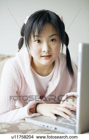 Picture - Portrait of a young woman using a laptop. Fotosearch