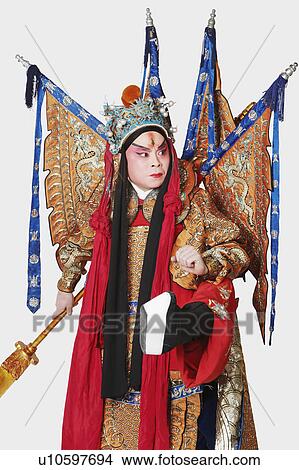 Picture - Close-up of a male Chinese opera performer holding a weapon. Fotosearch