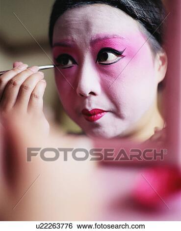 Stock Photograph - Close-up of a young woman applying eyeliner. Fotosearch