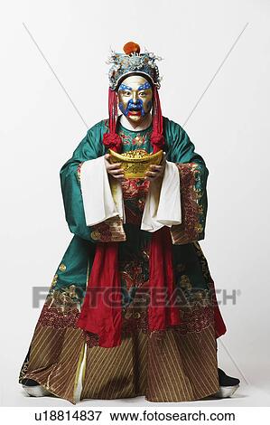 Stock Photo - Portrait of a male Chinese opera performer holding a bowl full of gold coins. Fotosearch