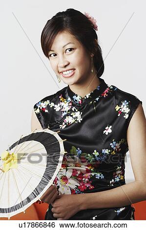 Stock Photograph - Portrait of a young woman holding a parasol. Fotosearch