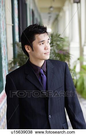 Stock Photo - Businessman standing and looking away. Fotosearch