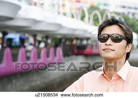 Close-up of a young man wearing sunglasses View Large Photo Image Picture - Close-up of a young man wearing sunglasses. Fotosearch